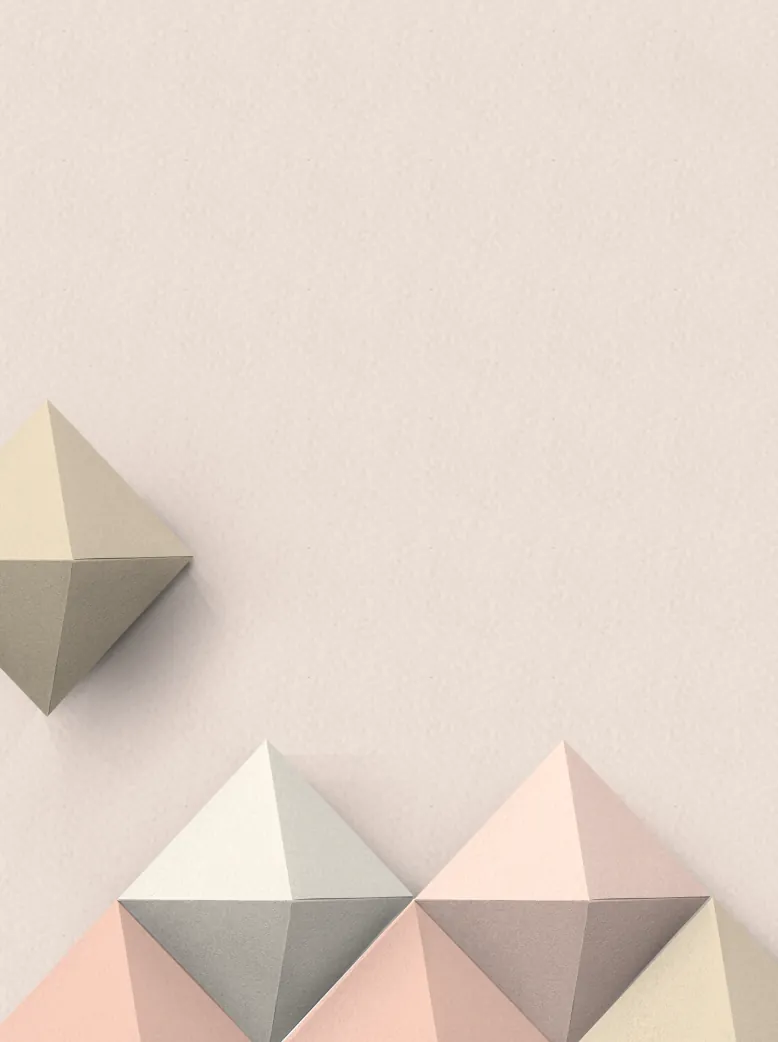 Pastel paper pyramids in beige, grey and pink on a cream background