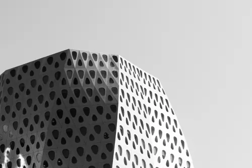 Black-and-white curved building facade with perforated panels