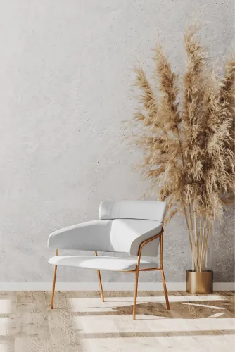 White chair beside pampas grass in a bright room with a wooden floor