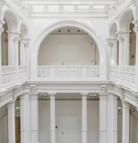 White neoclassical atrium with arches, balustrades and columns