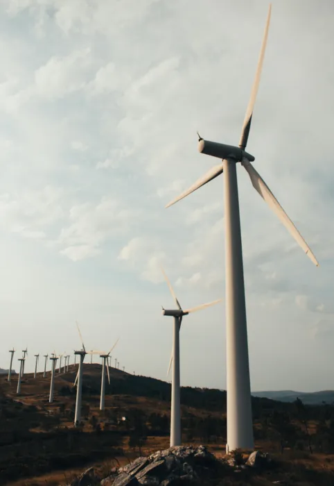 Wind turbines on a rocky hillside under a cloudy sky